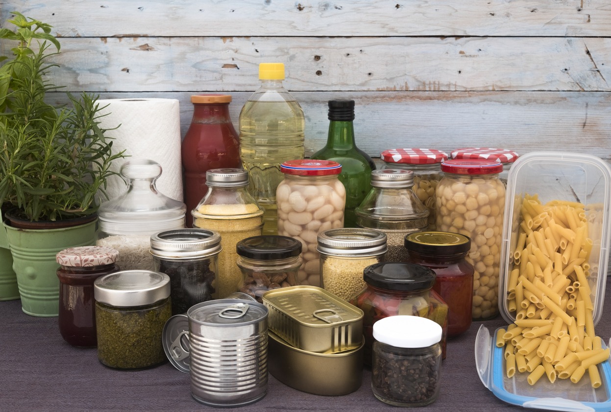 Covid-19 coronavirus infection. Small pantry of food for the period of isolation in quarantine. Several glass jars with cereals, legumes, jams, pasta and rice, canned cans