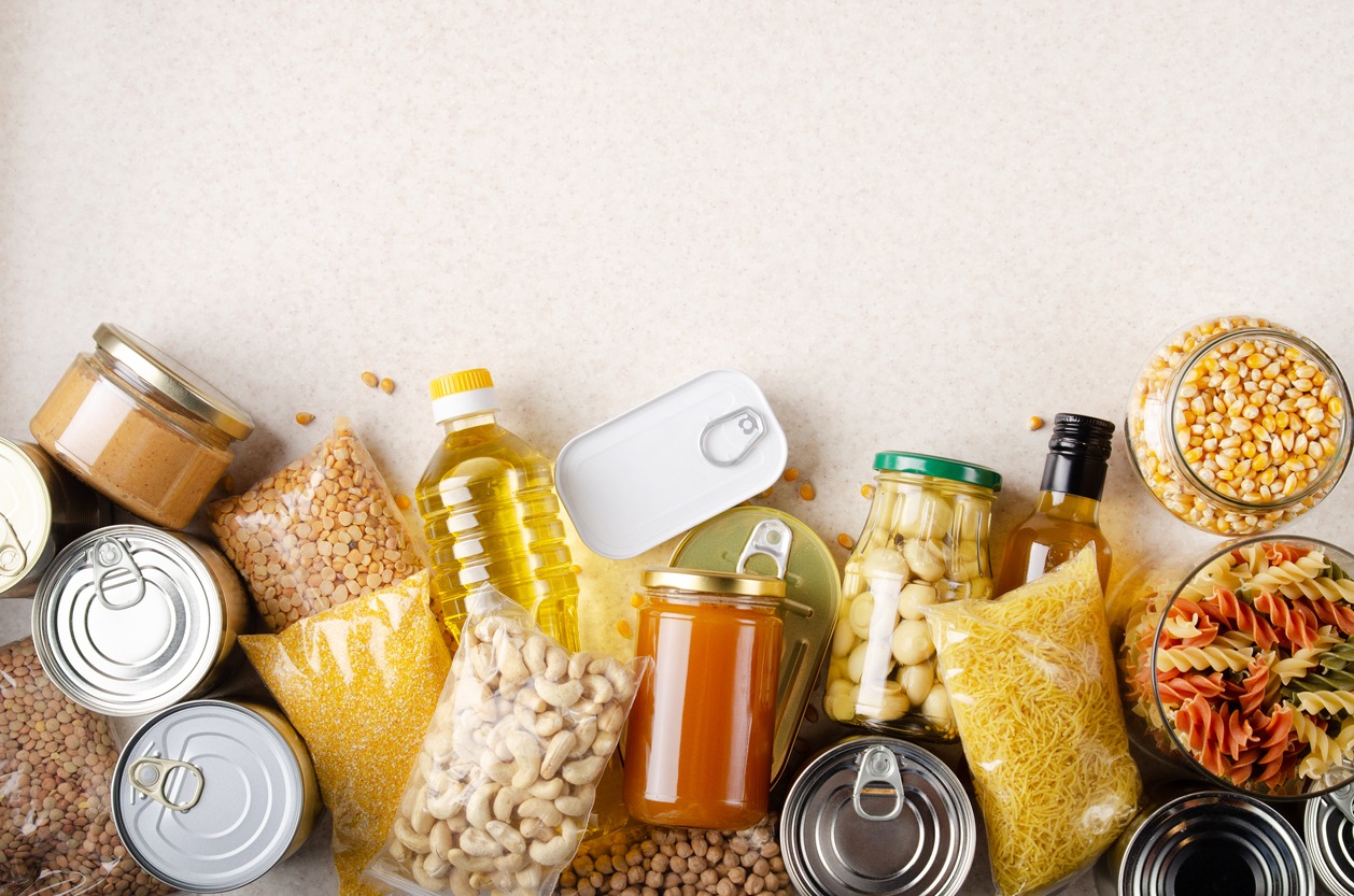 Flat lay view at kitchen table full with non-perishable foods. 