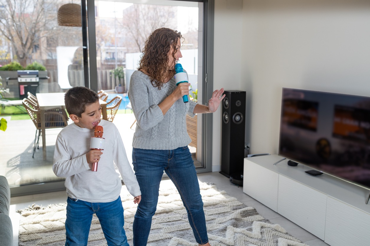 Mother and son singing karaoke at home
