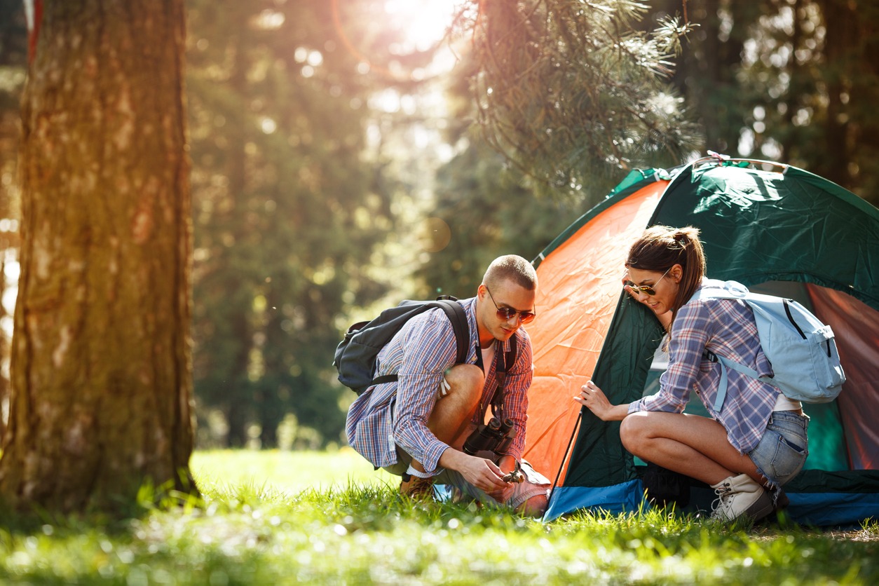two campers setting up a tent