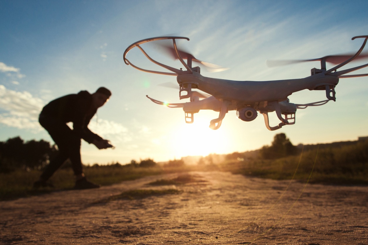 A man flying a drone low to the ground