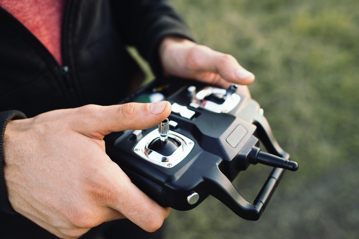 A man holding a remote control for a drone