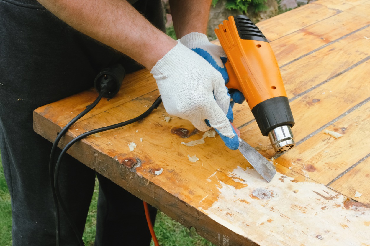 man removing old varnish from wood