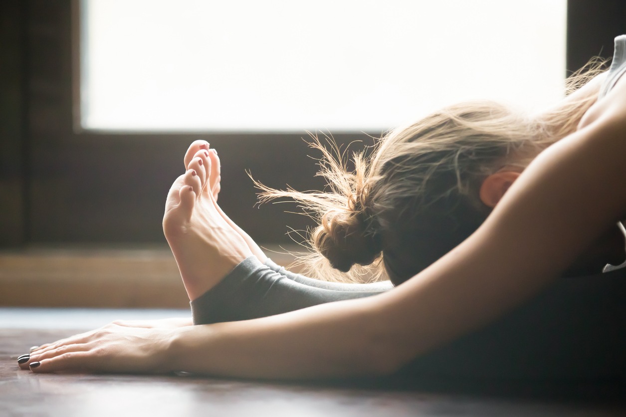A woman in a seated forward bend pose