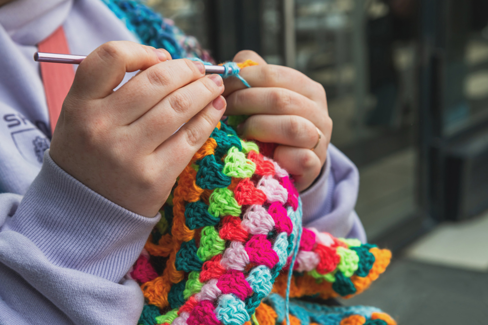 Crochet knitting from multi-colored yarn. Selective focus