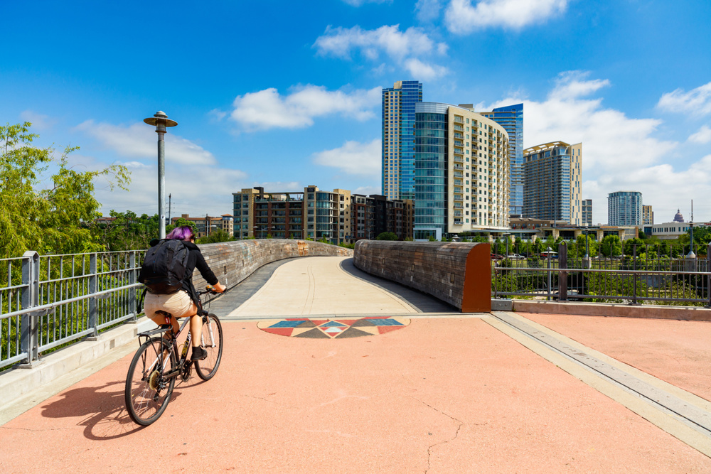 A man biking in the Lamar Pedestrian Bridge in Austin
