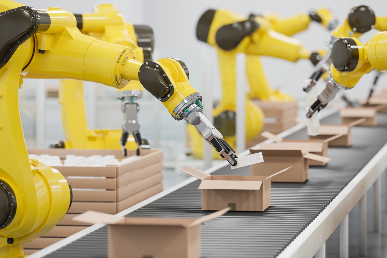 Robotic arms packing items on a conveyor belt