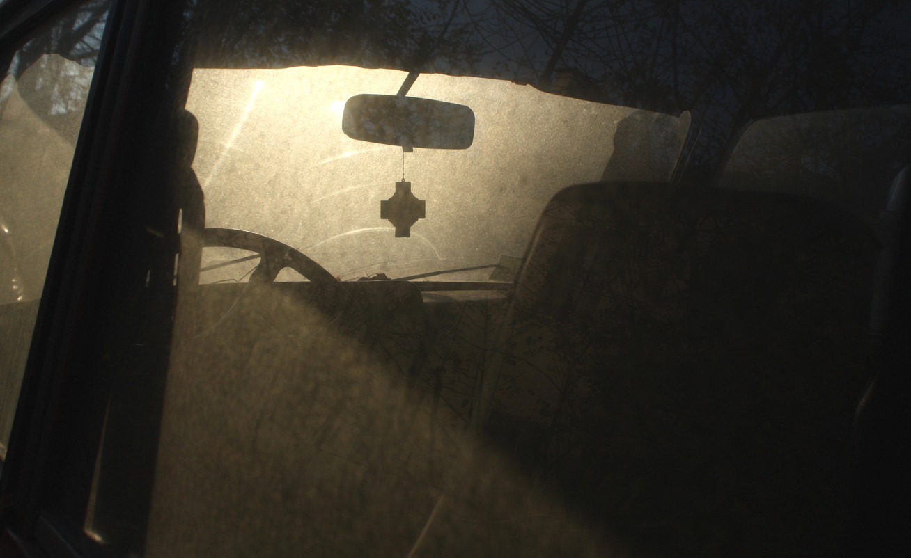 A catholic cross inside a dark car