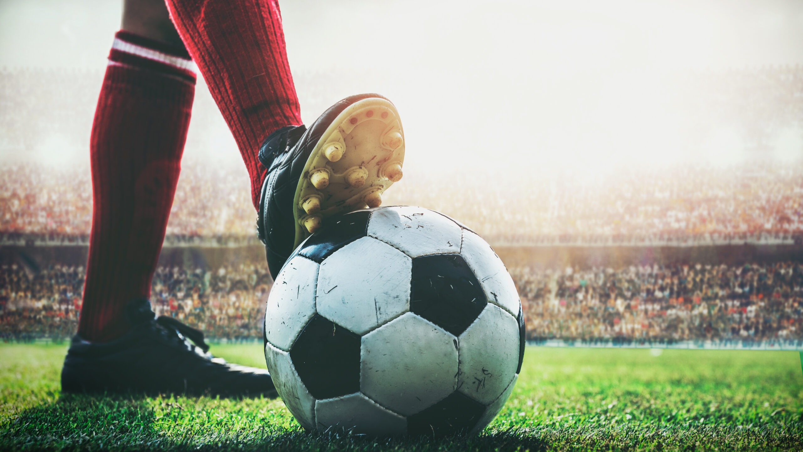 Feet of soccer player tread on a soccer ball for kick off in the stadium