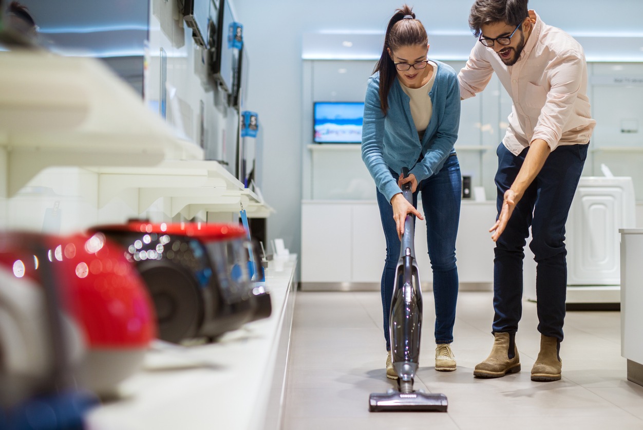 A couple testing out a vacuum cleaner