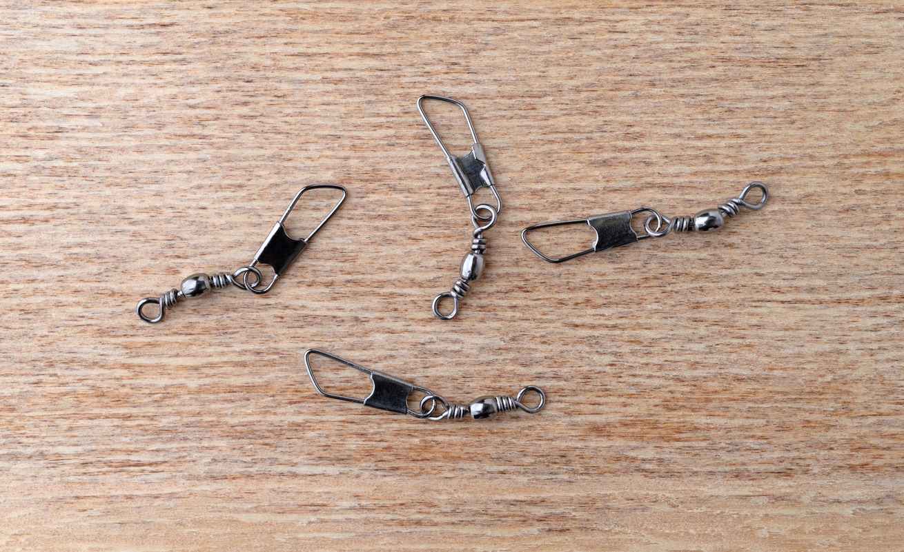 four snap swivels on a wooden table