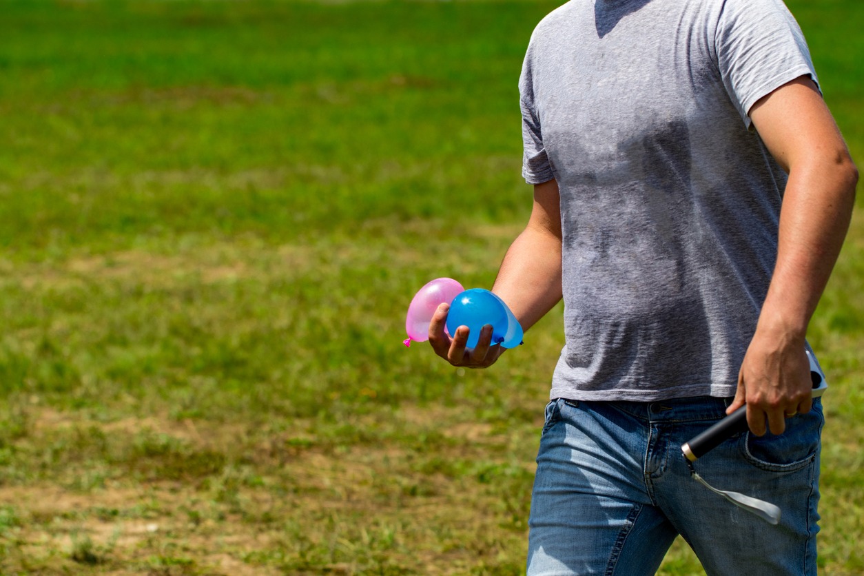 A man carrying two water balloons