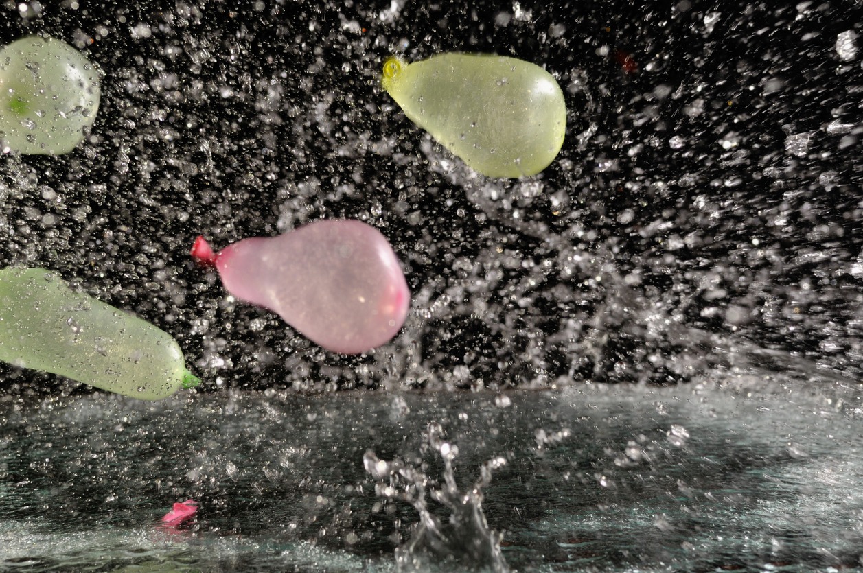 Multiple water balloons being thrown with a considerable force