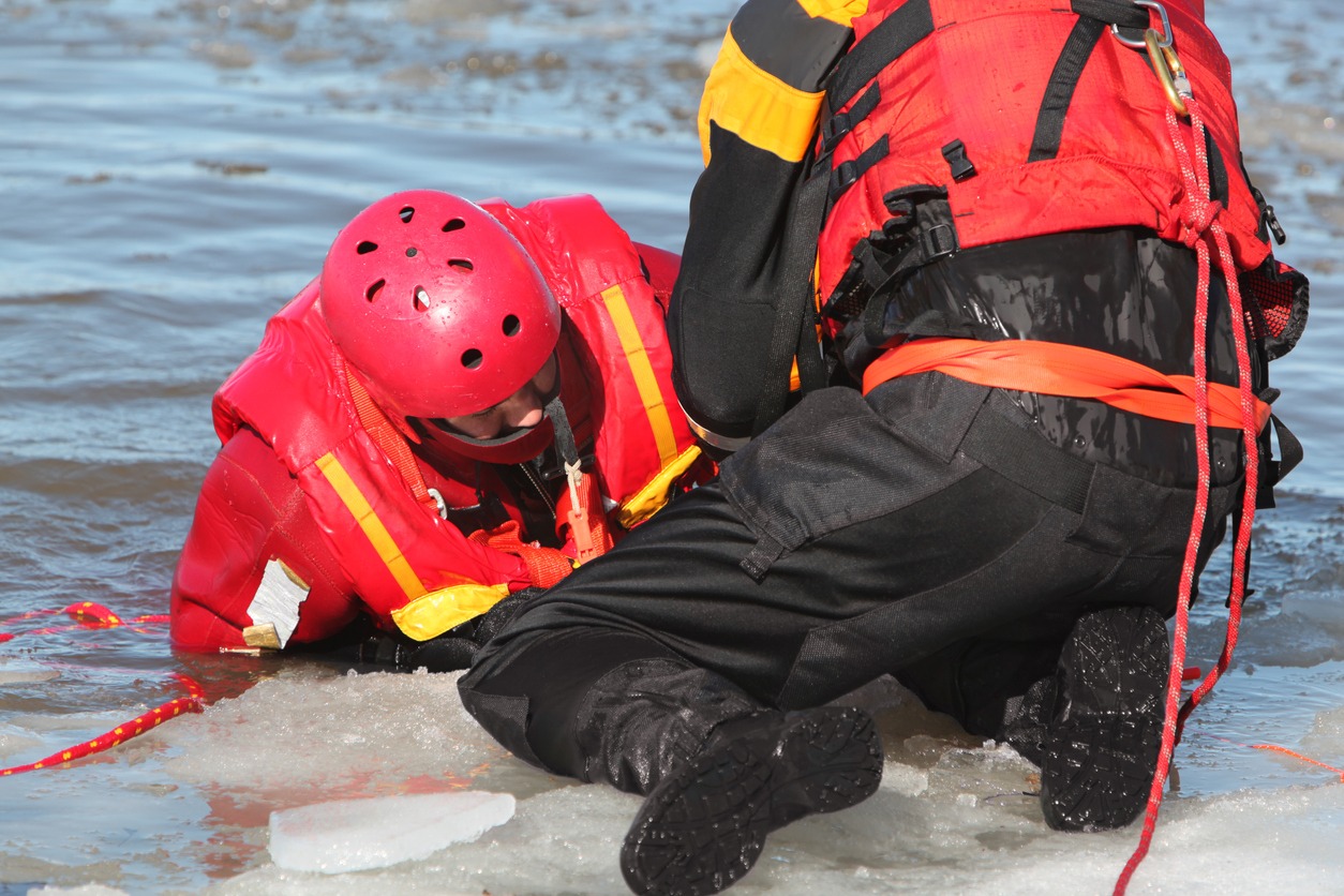Two rescuers in ice-covered water.