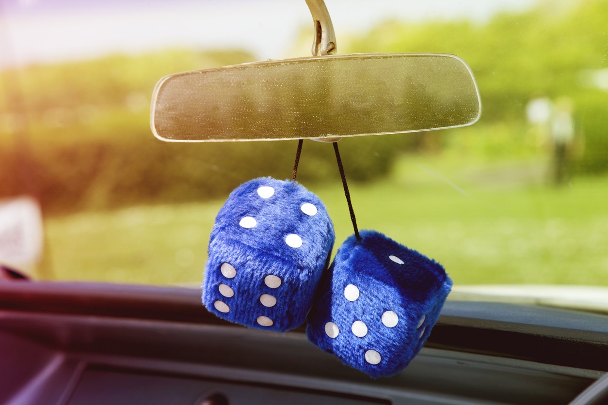 Blue furry dice hanging from a car mirror