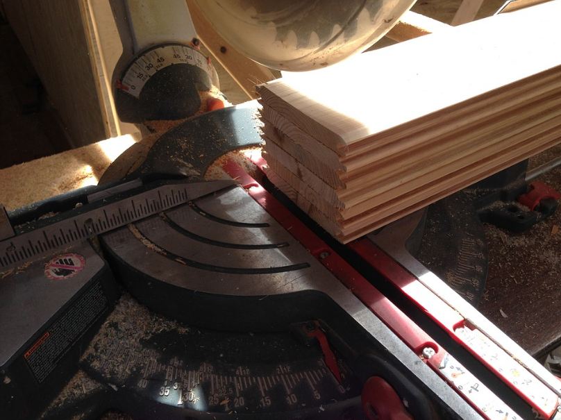 a miter saw cutting through multiple wood planks.