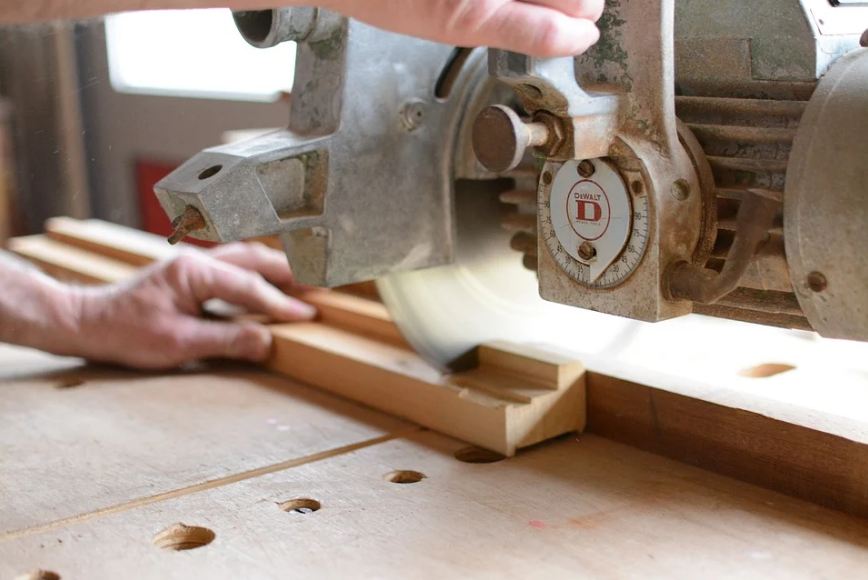 an electrical saw cutting wood planks.