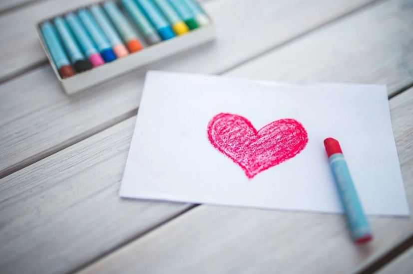 Picture of card with a heart and crayons.