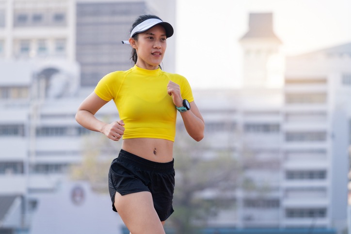 A young Asian woman athlete runner jogging on running track