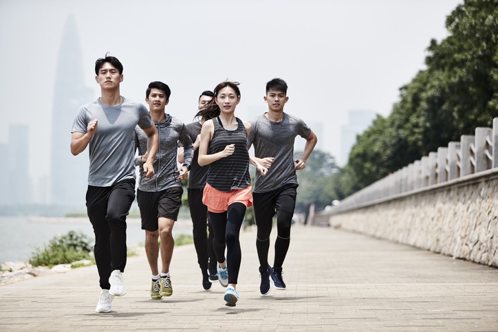 group of young asian adults running outdoors