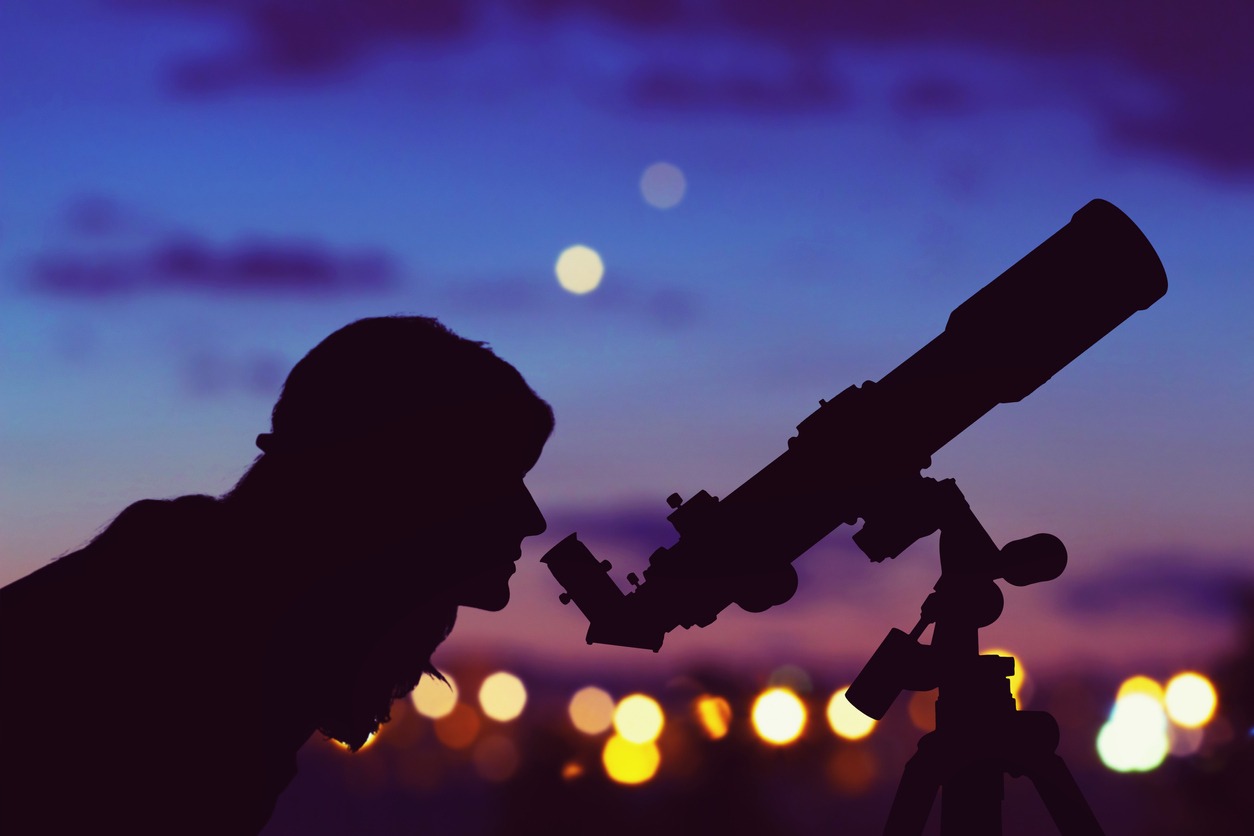 girl looking at the stars with a telescope
