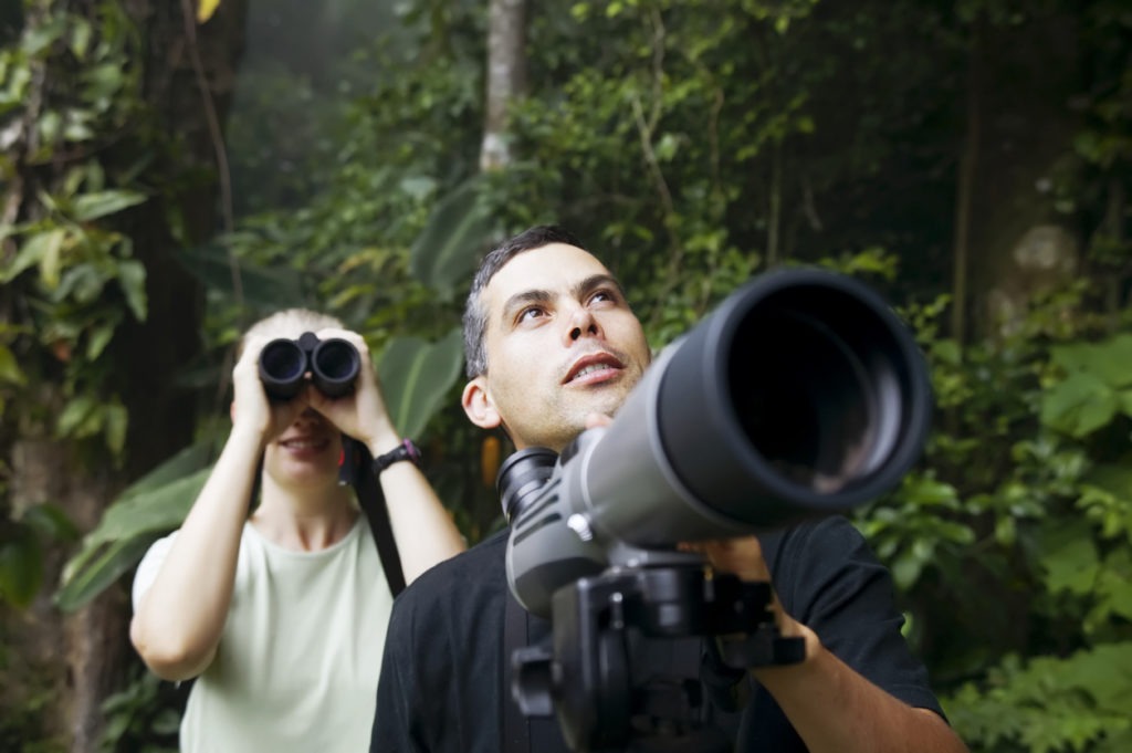 Woman using Binoculars and Man with Telescope