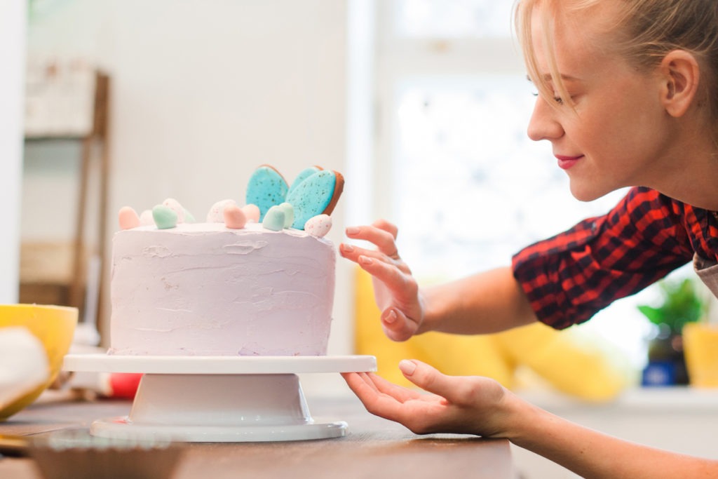 woman decorates a homemade cake for business