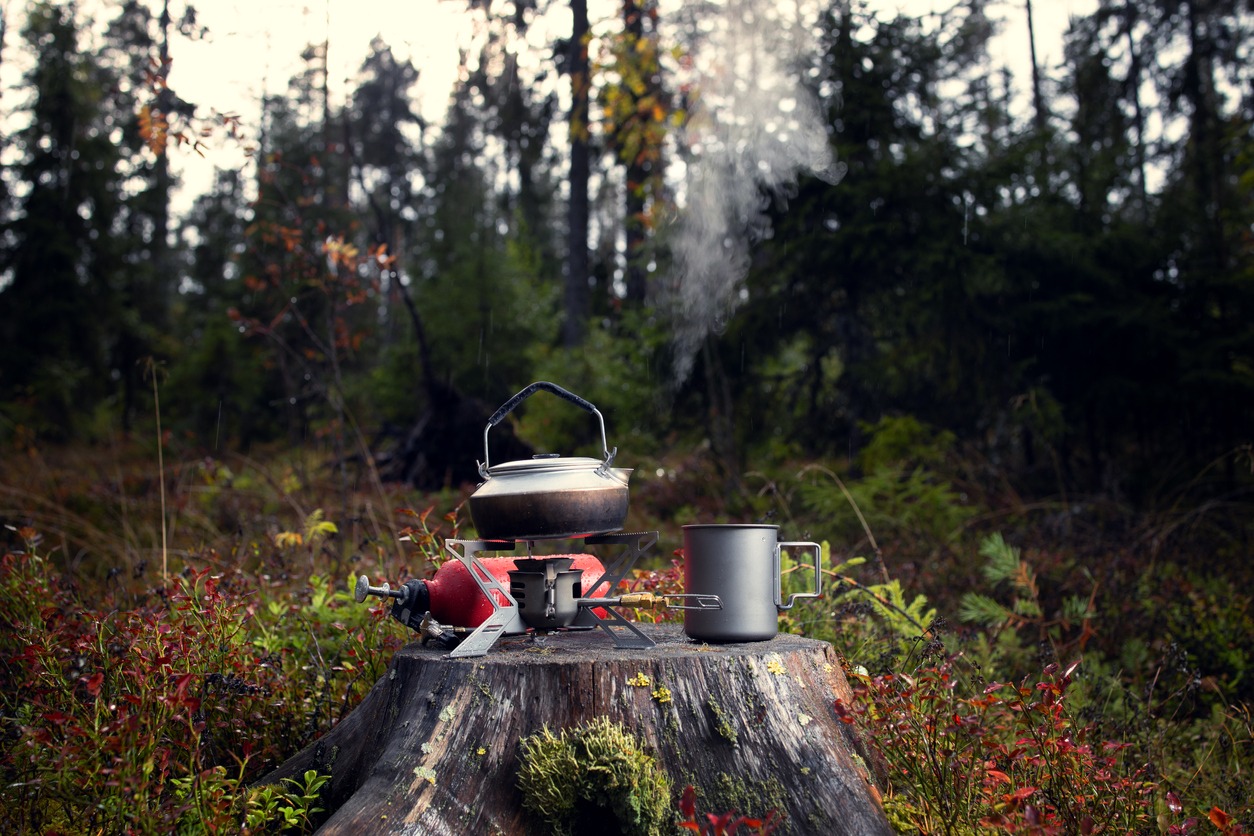 A camping stove with mug and kettle