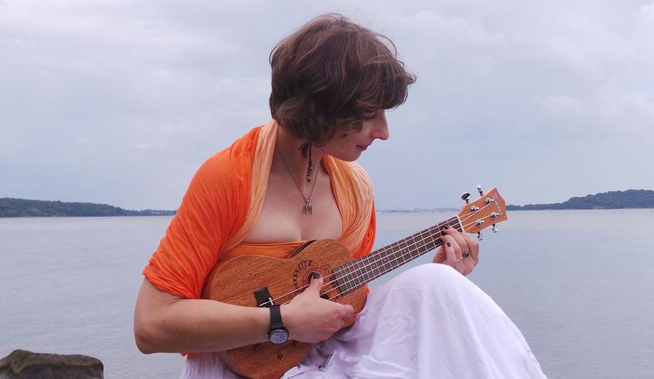A woman playing ukulele outdoors