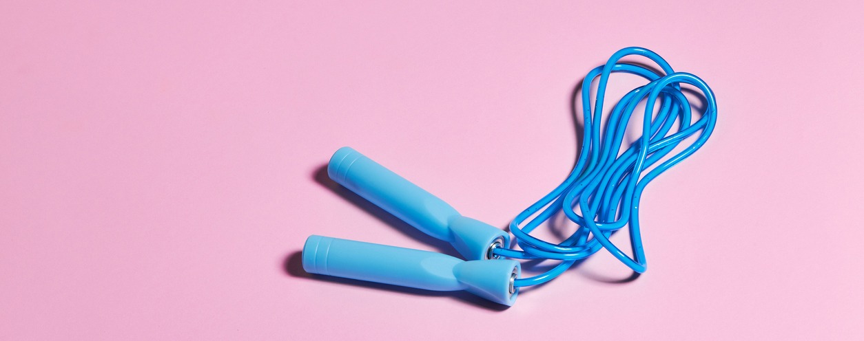 Blue skipping or jump rope against a pink background.