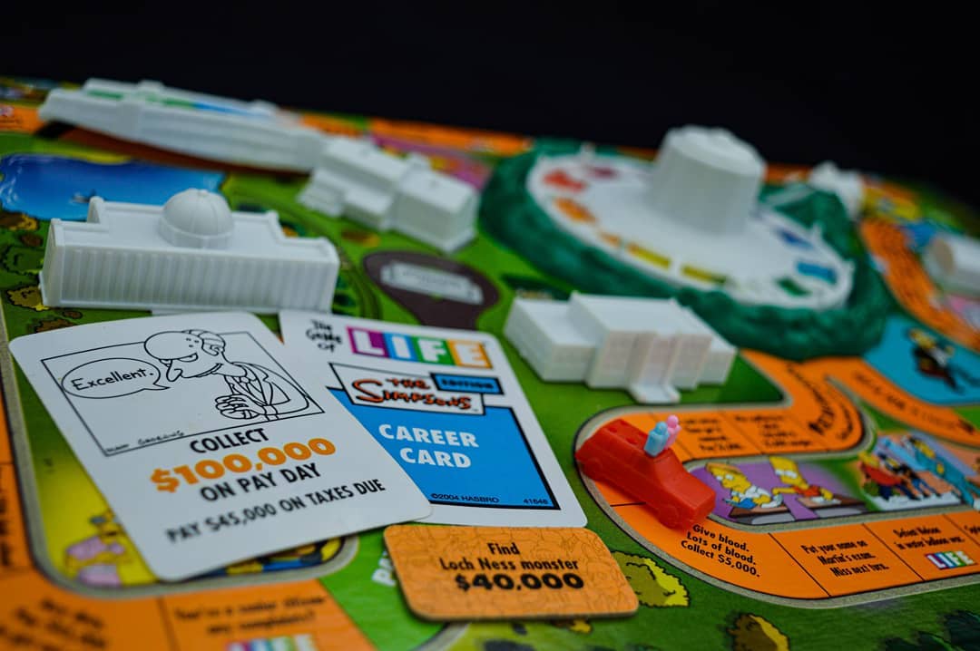 Close-up view of the action card and career card on top of the board of game of life