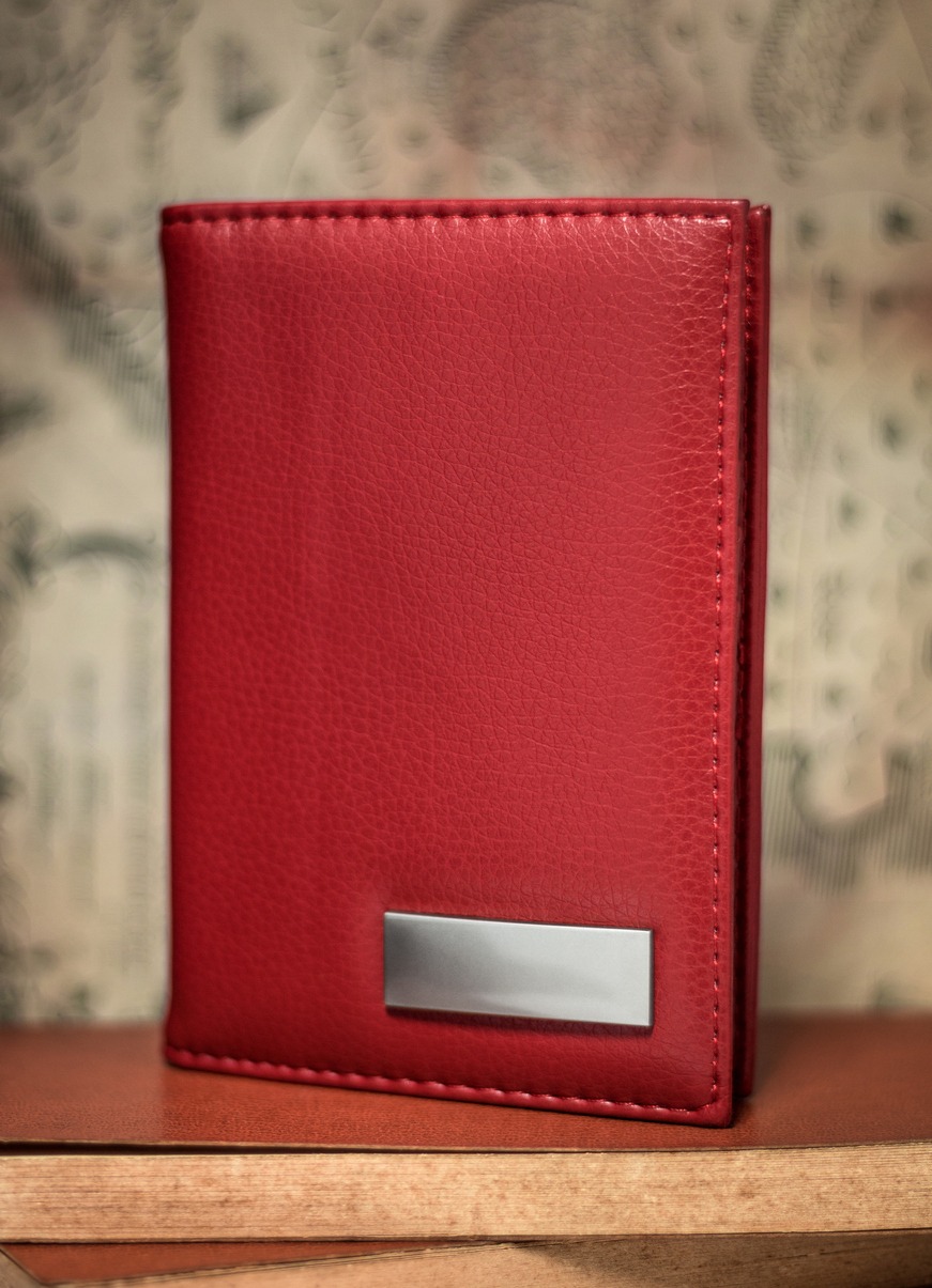 Red passport case against antique backdrop