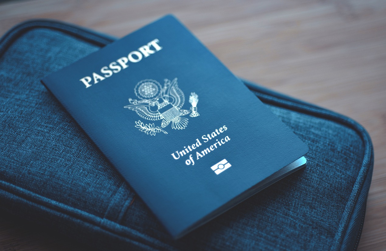 United States of America passport on a blue travel wallet with a wooden background