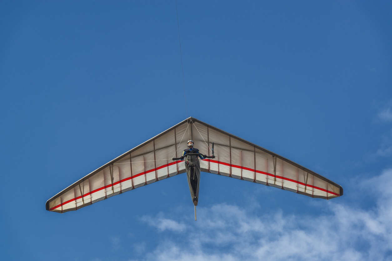 Bright hang glider wing silhouette from below. Extreme sport