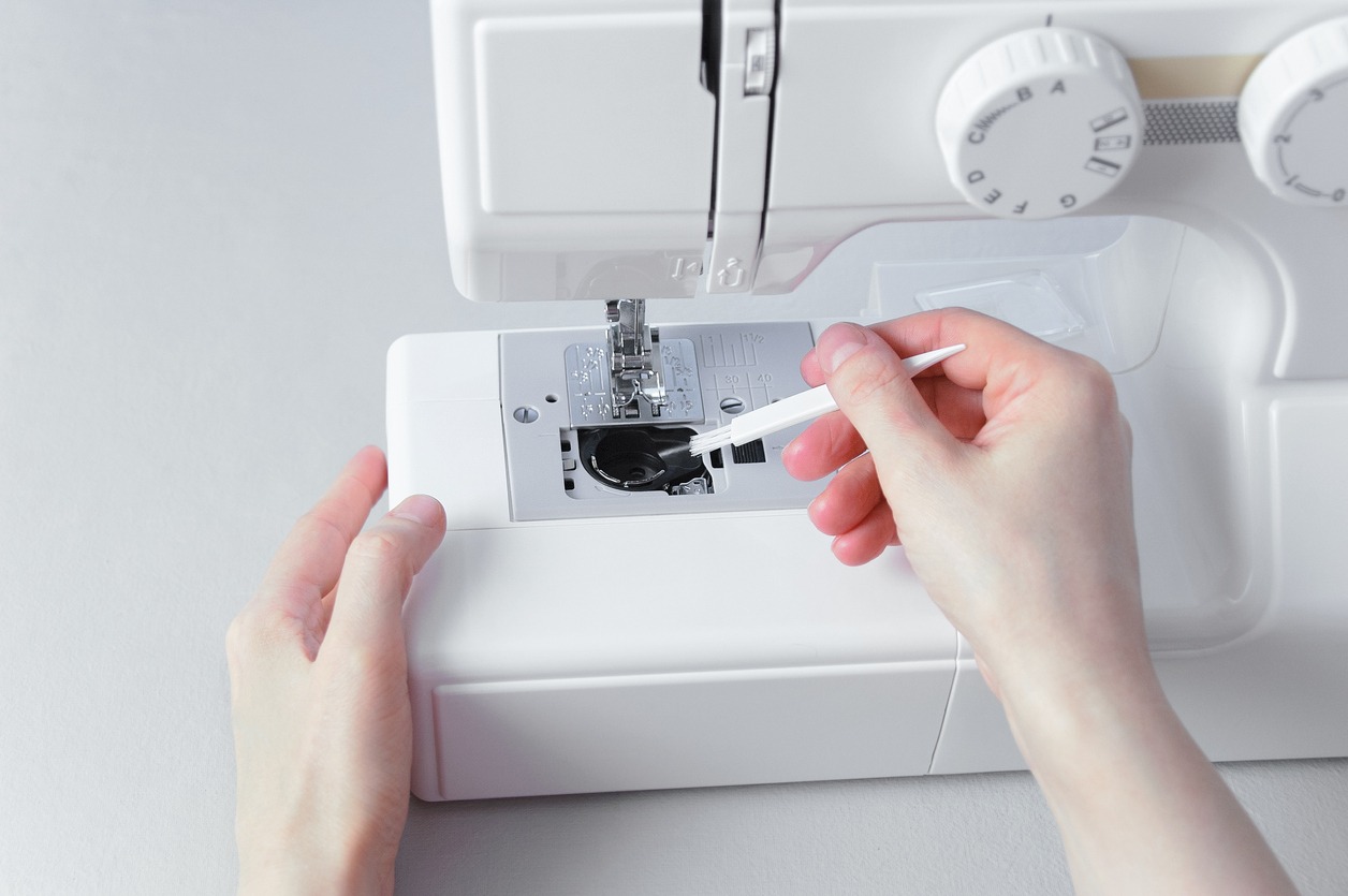 Cleaning the sewing machine with brush