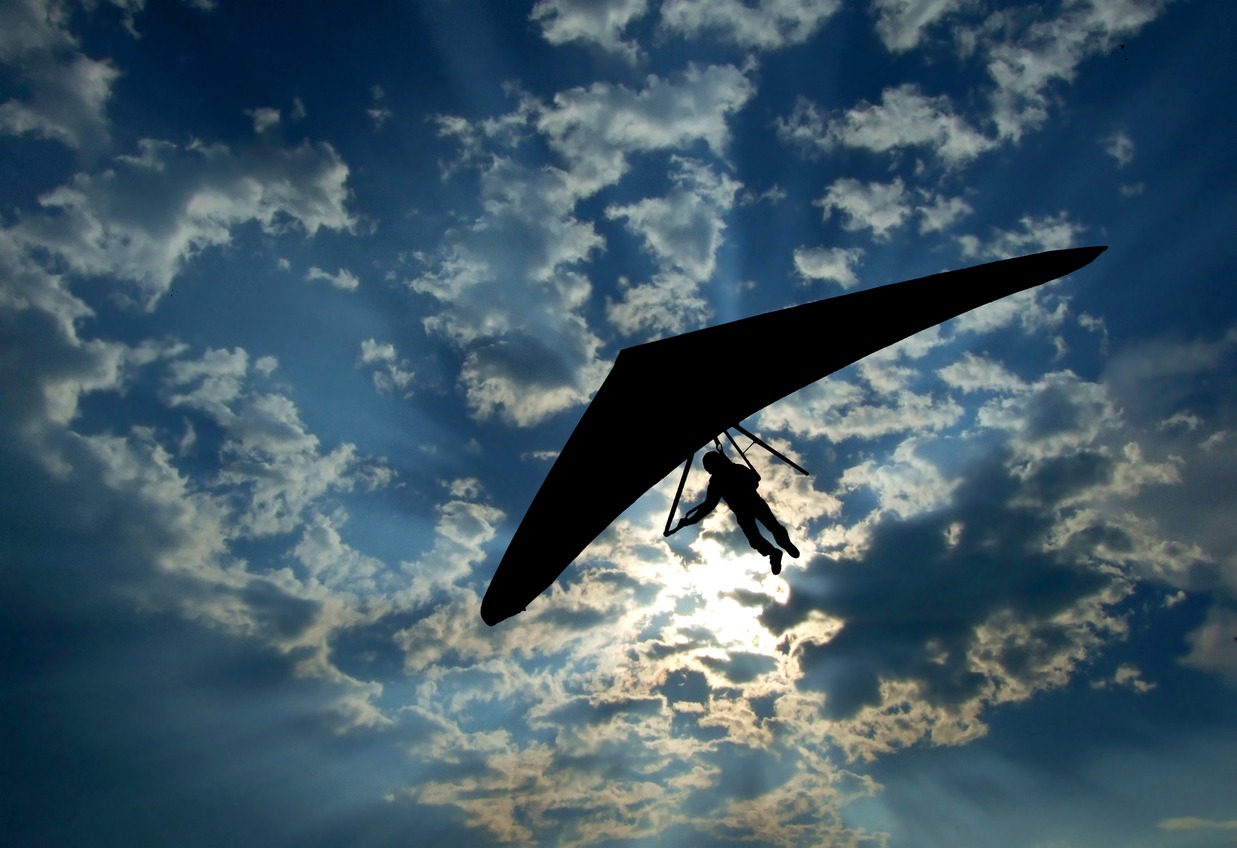 Hang glider silhouette on sky