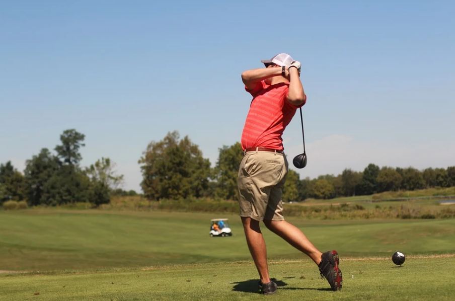 man-swinging-his-golf-club-at-a-golf-course