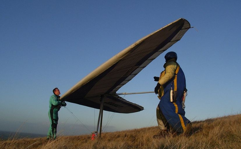 men-preparing-for-hang-gliding-tall-grass-huge-hang-glider