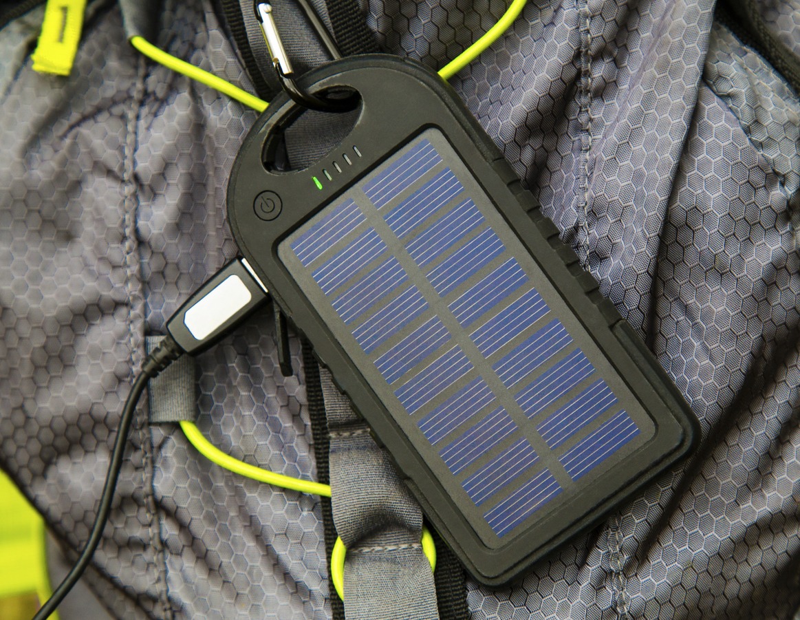 Portable solar cell hanging on tourist backpack