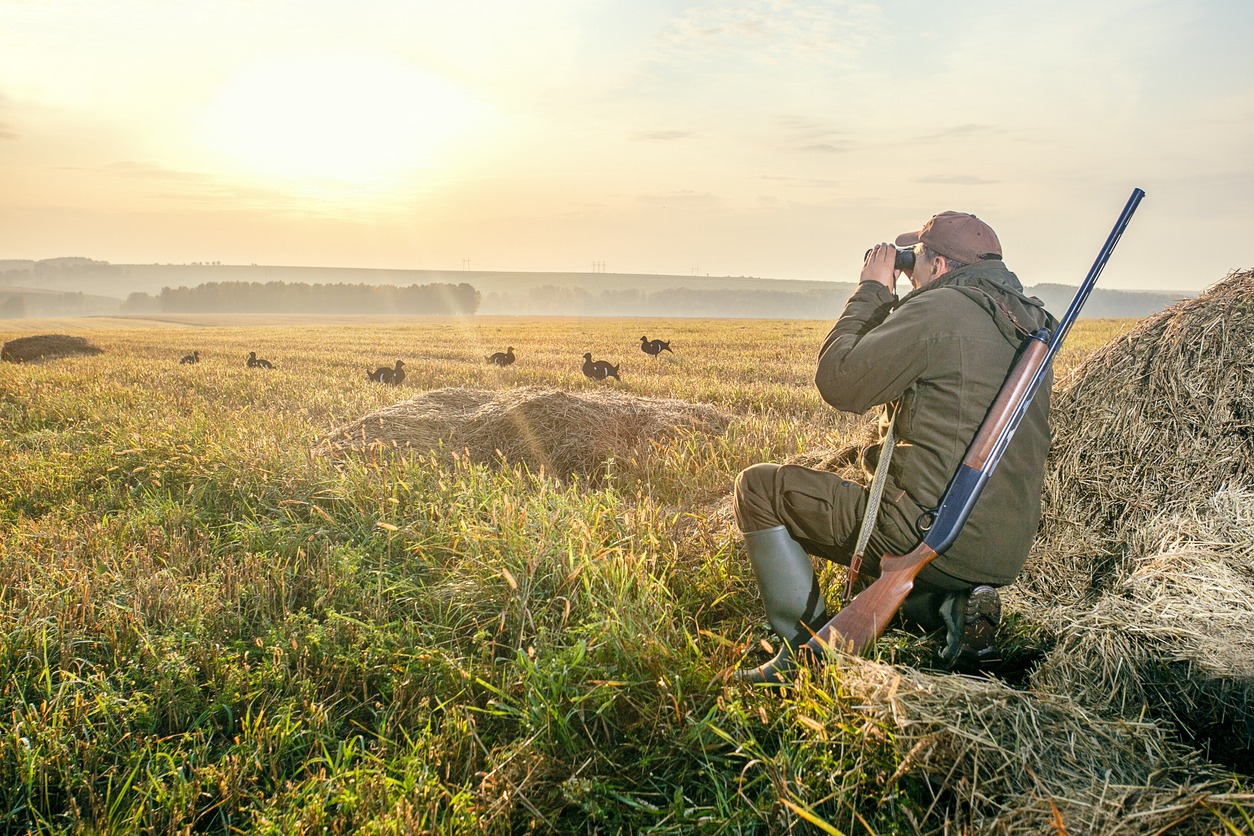 A hunter checking out prey using his binoculars