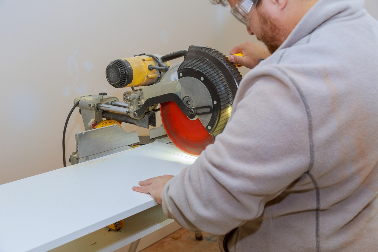 A man cutting laminated shelves with a circular saw
