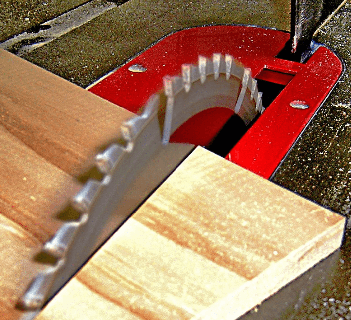 The blade of a table saw cutting into wood