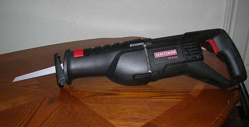 a black reciprocating saw on a table