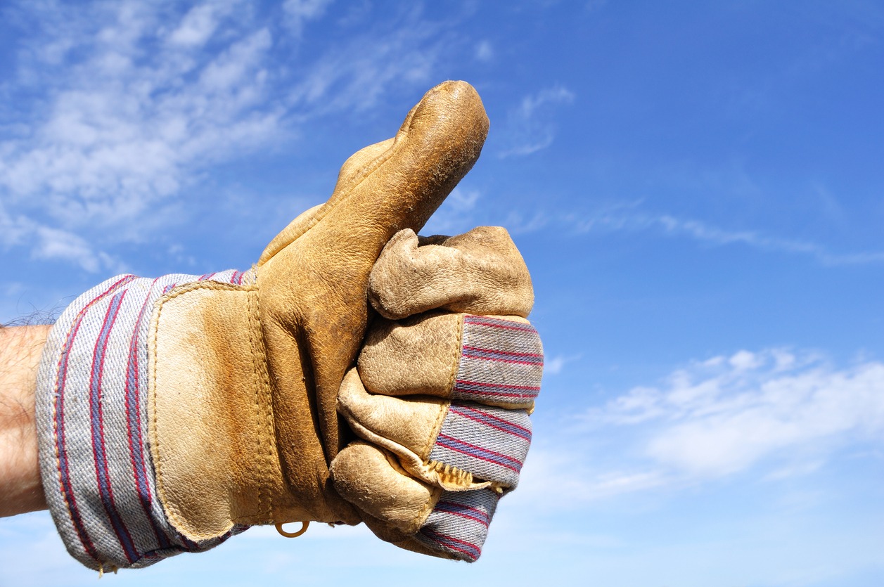 a hand wearing a work glove giving a thumbs up