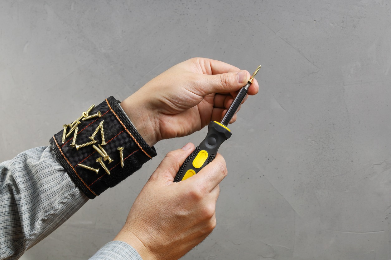 a person wearing a magnetic wristband preparing to install a screw
