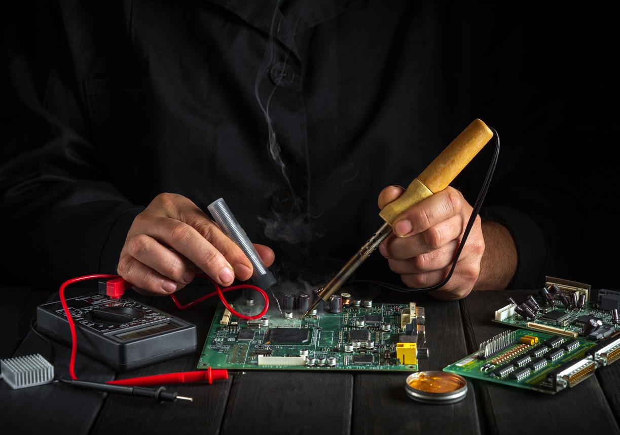 a specialist working on computer repair with soldering tools