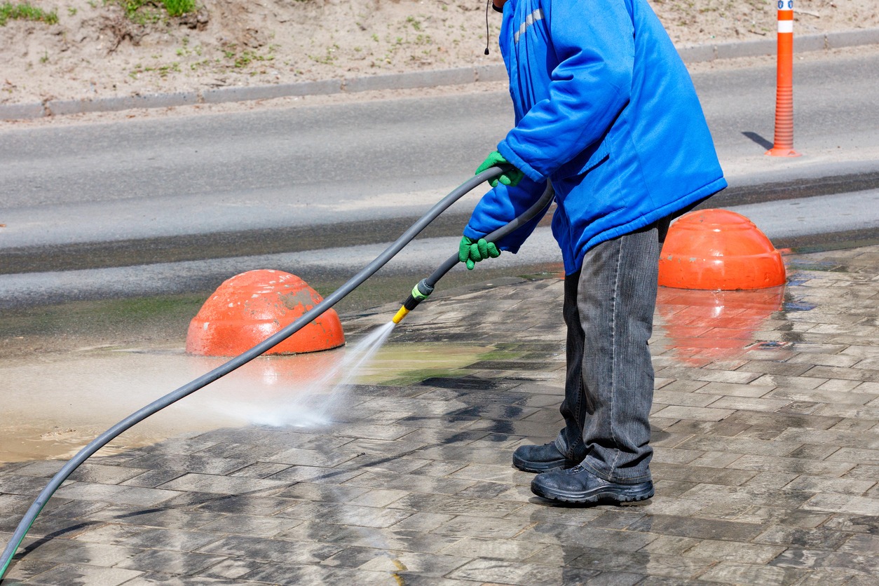 man using pressure washer with extended hose