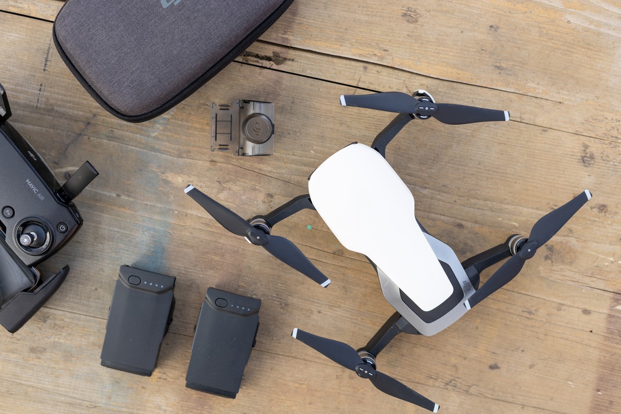 A Mavic Air 4 with its batteries and a carrying case