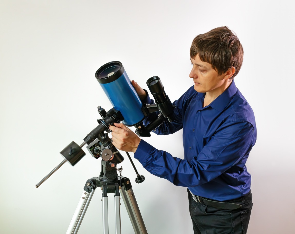 A man adjusting a telescope