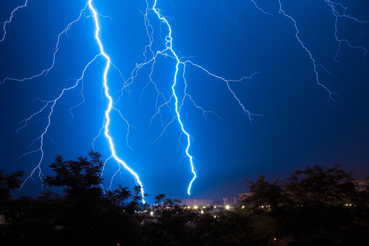 A picture of multiple lighting strikes over a city. 
